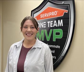 A lady standing in front of SERVPRO sign.