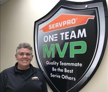 A lady standing in front of SERVPRO sign.